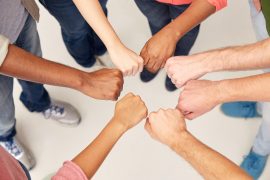 teamwork, friendship, international, gesture and people concept - group of hands making fist bump